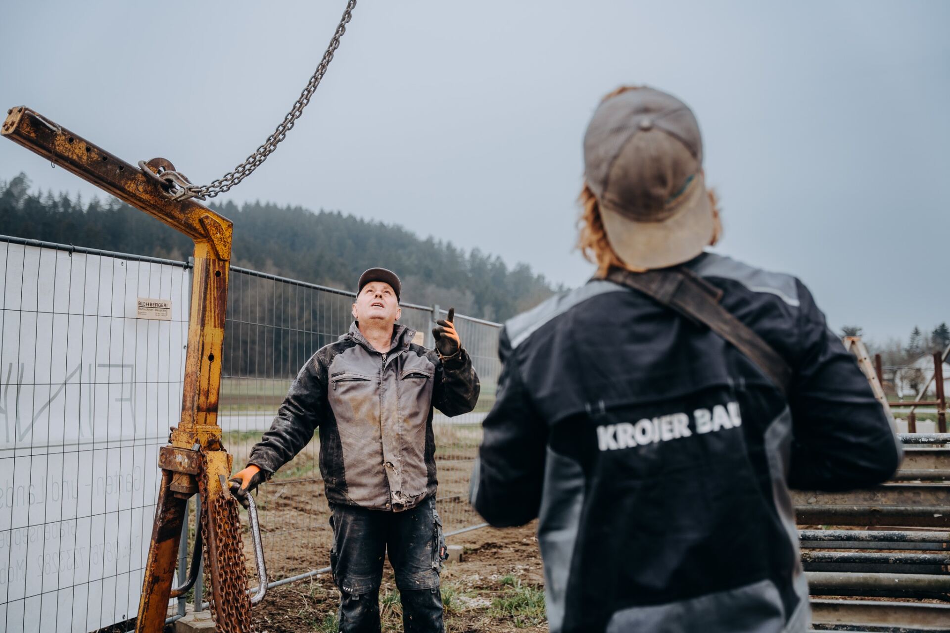 Krojer Bau – Zwei Krojer Bau Mitarbeiter koordinieren Kranarbeit auf dem Feld