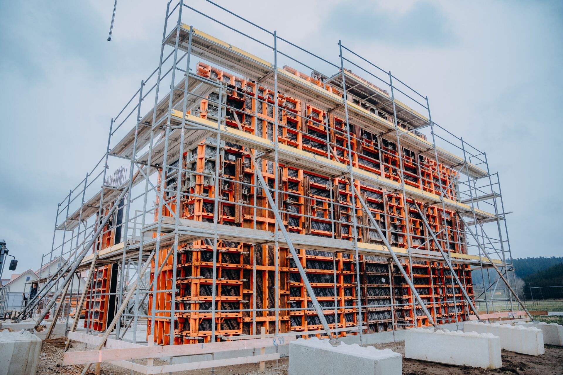 Krojer Bau – Imposante orange Schalung mit Gerüst auf Großbaustelle
