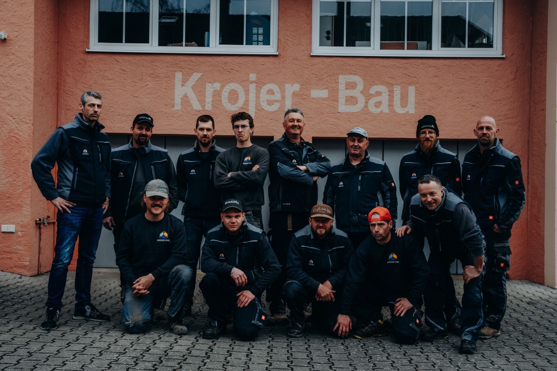 Gruppenfoto des kompletten Krojer Bau Teams vor dem Firmengebäude in Mauern